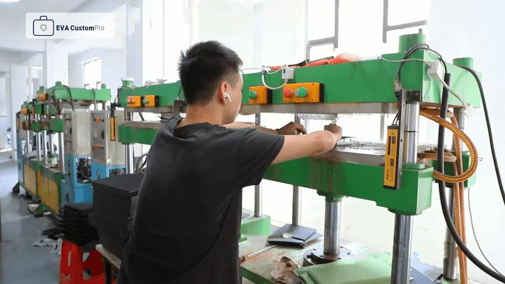 Factory technician operating a thermoforming hydraulic press machine for custom EVA case OEM ODM manufacturing.